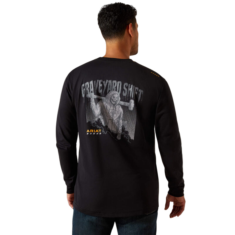 Man wearing a black long-sleeve shirt with 'Graveyard Shift' design on the back, standing against a beige background.