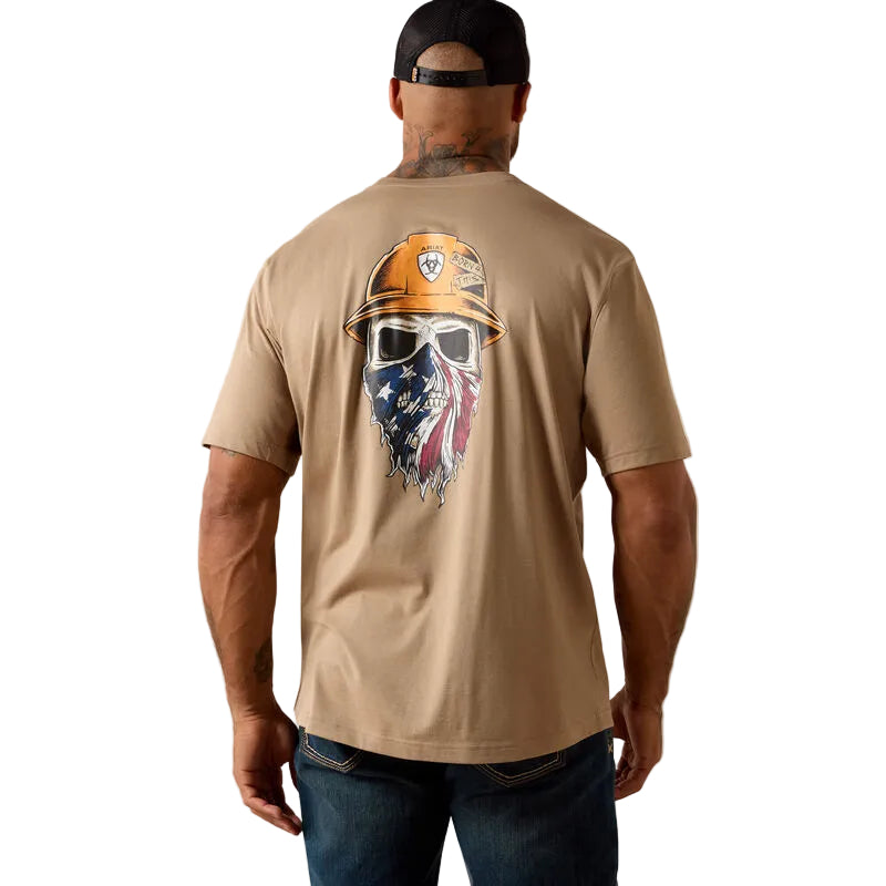 Man wearing a tan t-shirt with a graphic design on the back, featuring a helmet and American flag.