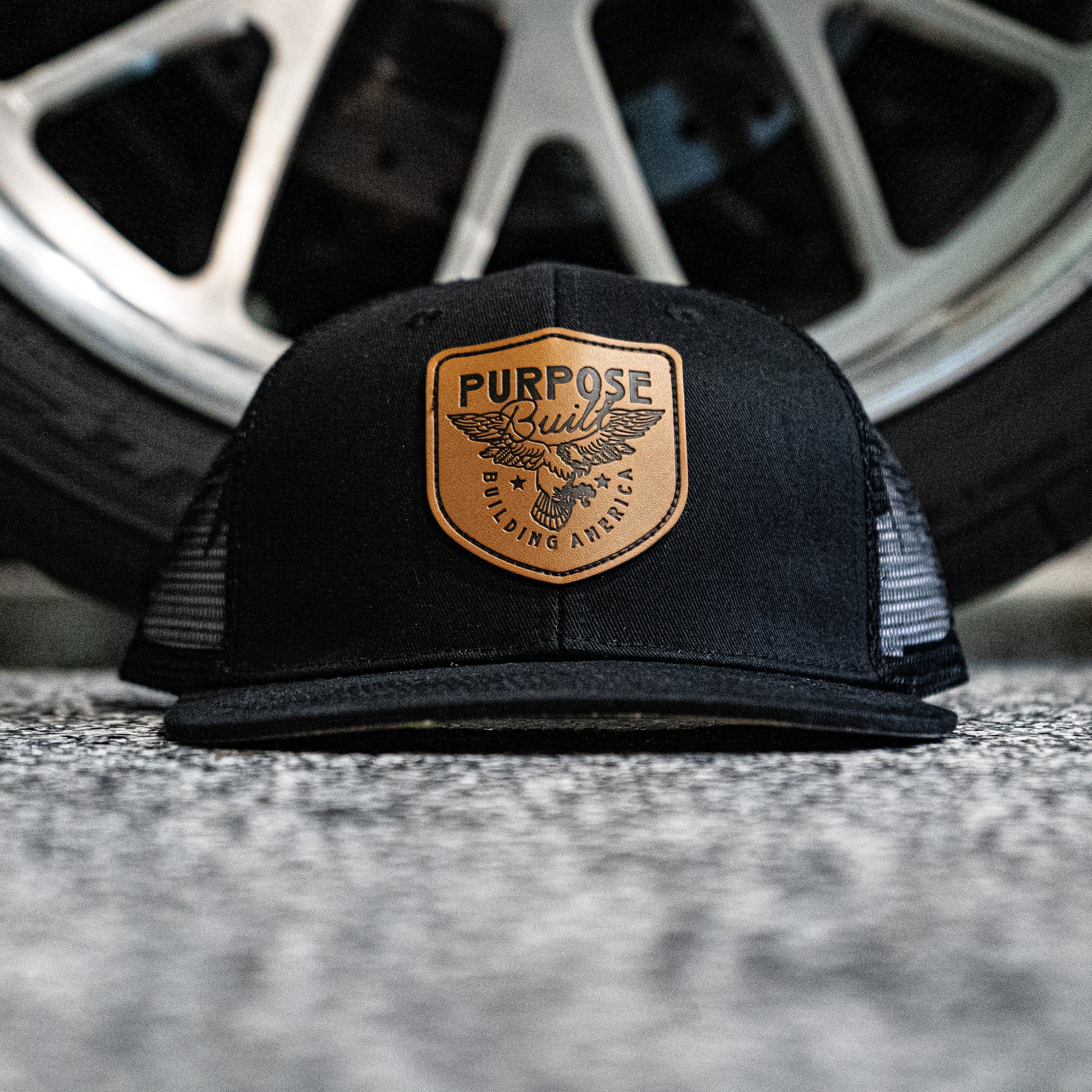 Black cap with a logo on a car tire background