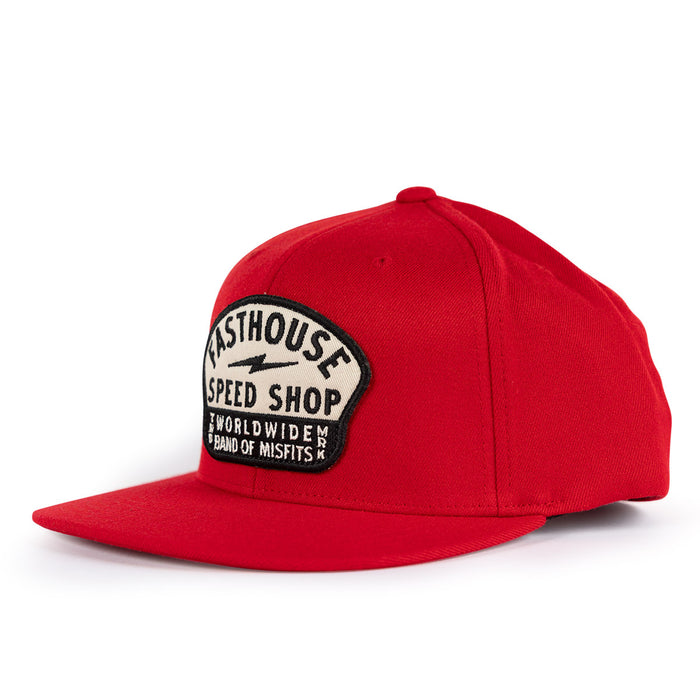 A red flat-brim baseball cap featuring a black and white embroidered patch on the front that reads 'FASTHOUSE SPEED SHOP WORLDWIDE BAND OF MISFITS'.