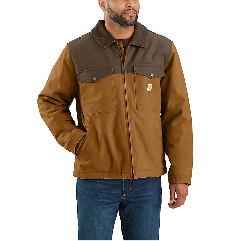 A man wearing a Carhartt Montana Relaxed Fit Insulated Jacket in brown and coffee color blocks, paired with blue jeans.